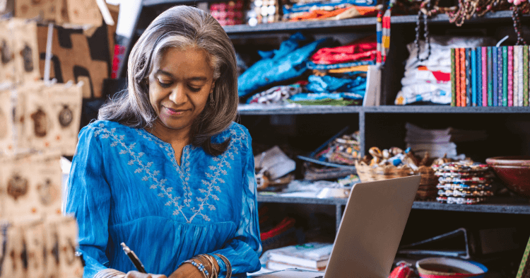 Woman wearing a blue tunic looking at small business line of credit uses.