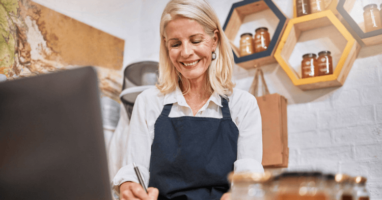 Female small business owner smiles at her laptop.